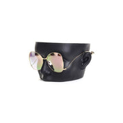 Silmälasiteline, kasvot mustassa. 1 pari silmälaseja.