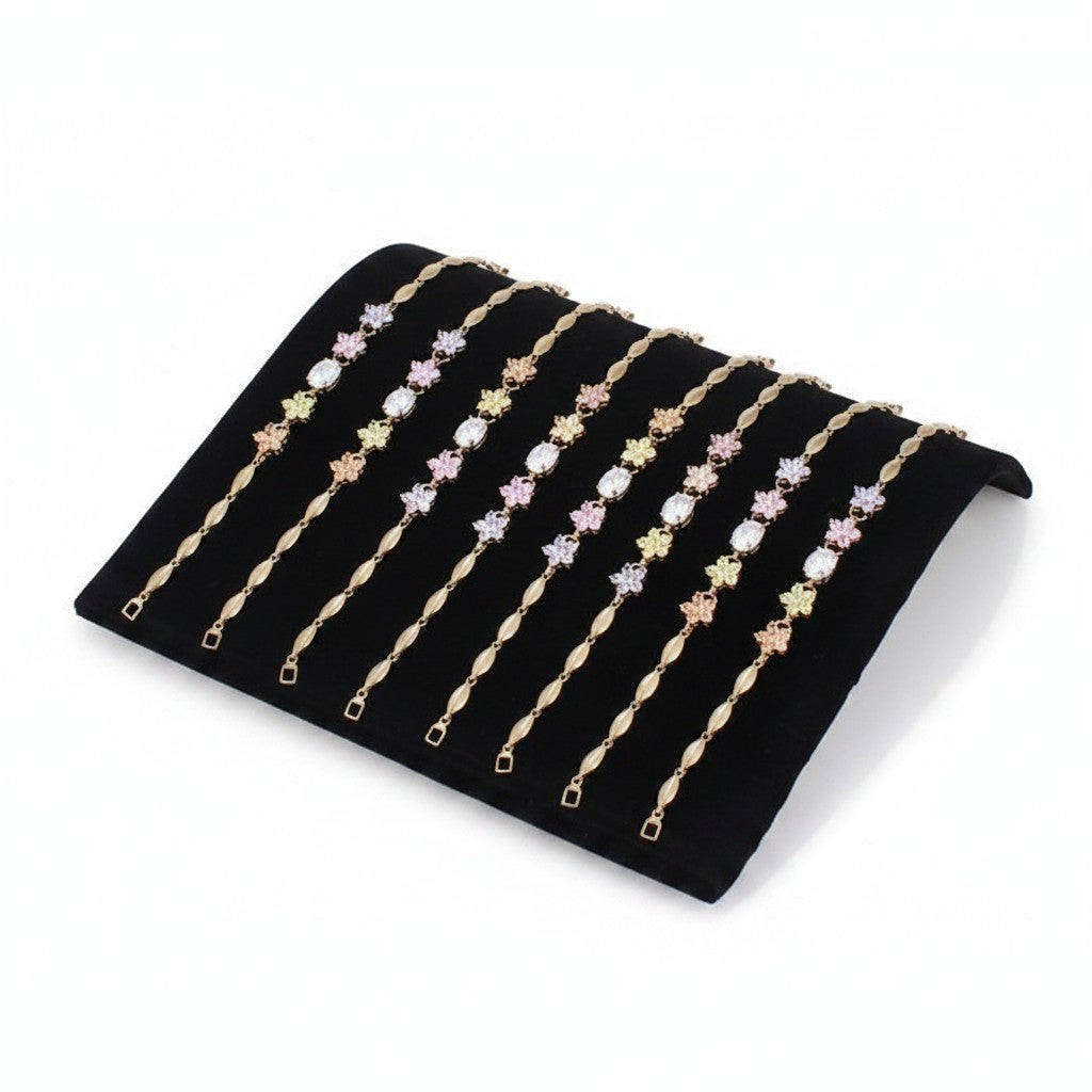SuperSellerS black flocked curved jewelry display tray holding eight delicate gold bracelets with floral accents