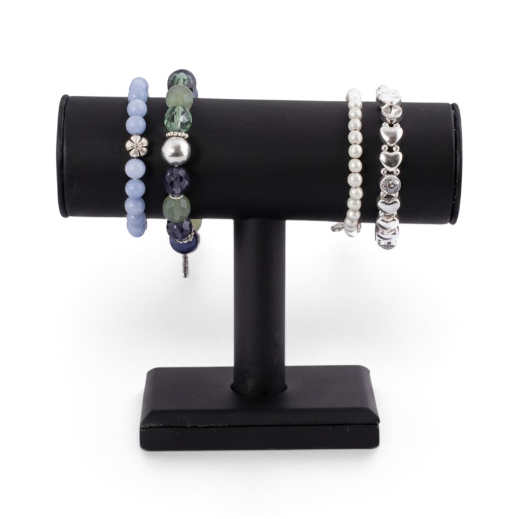 SuperSellerS black faux leather T-bar bracelet display stand holding four assorted beaded and silver bracelets.