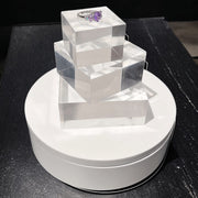 SuperSellerS white electronic rotating display stand with clear acrylic blocks showcasing a purple gemstone ring